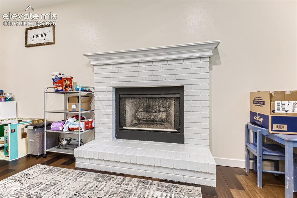 Image 34 of 49: White-painted brick fireplace with a black firebox and a decorative mantel