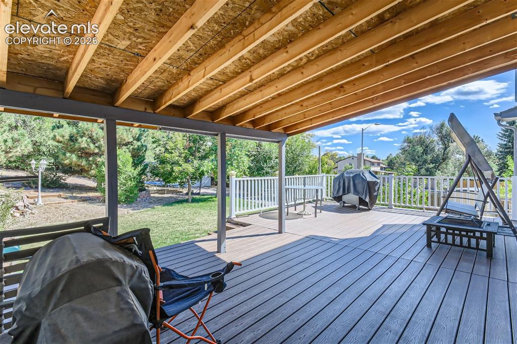 Image 35 of 49: Expansive covered deck featuring wood-finish decking, exposed wood beam cei