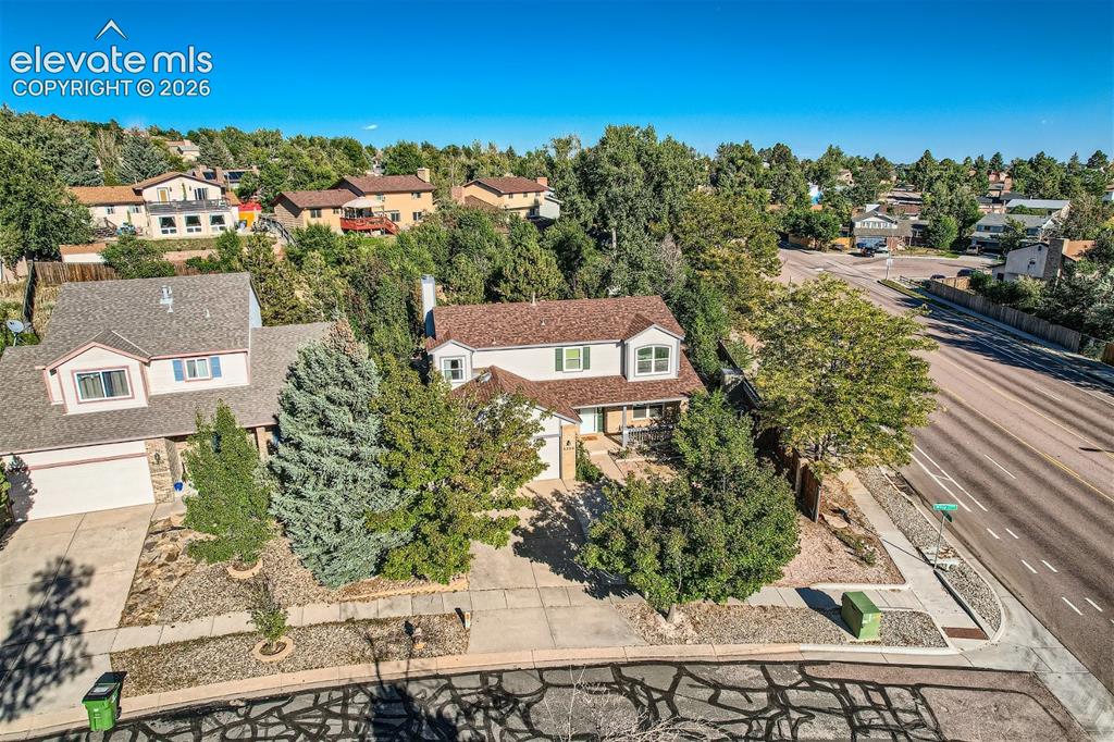 Image 47 of 49: Two-story residence featuring a shingled roof and front-facing garage