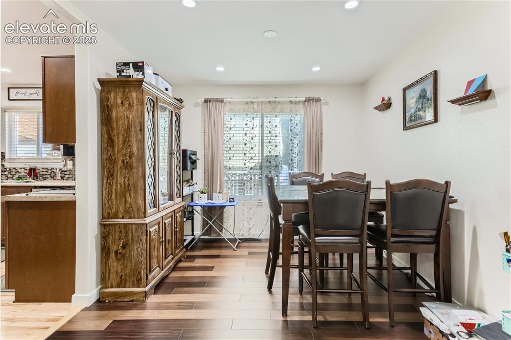 Image 8 of 49: Recessed lighting illuminates the space, featuring wood-finish flooring and