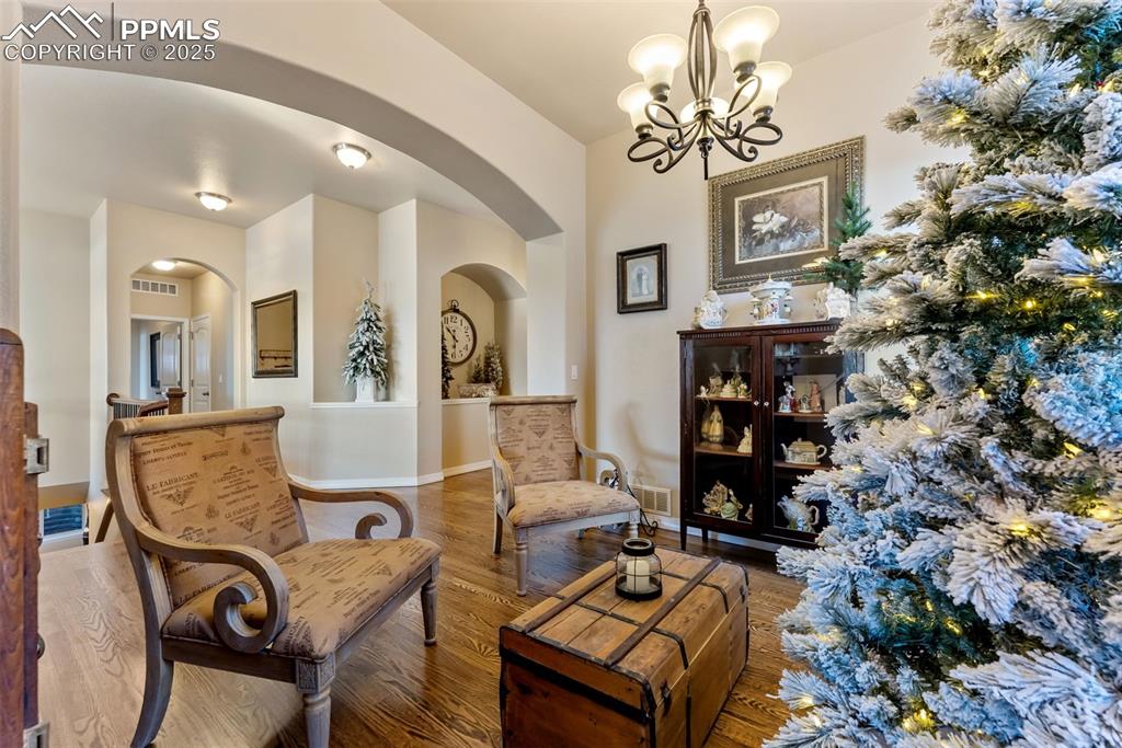 Image 10 of 50: Dining room with hardwood floors, a chandelier. Easily fits dining table,