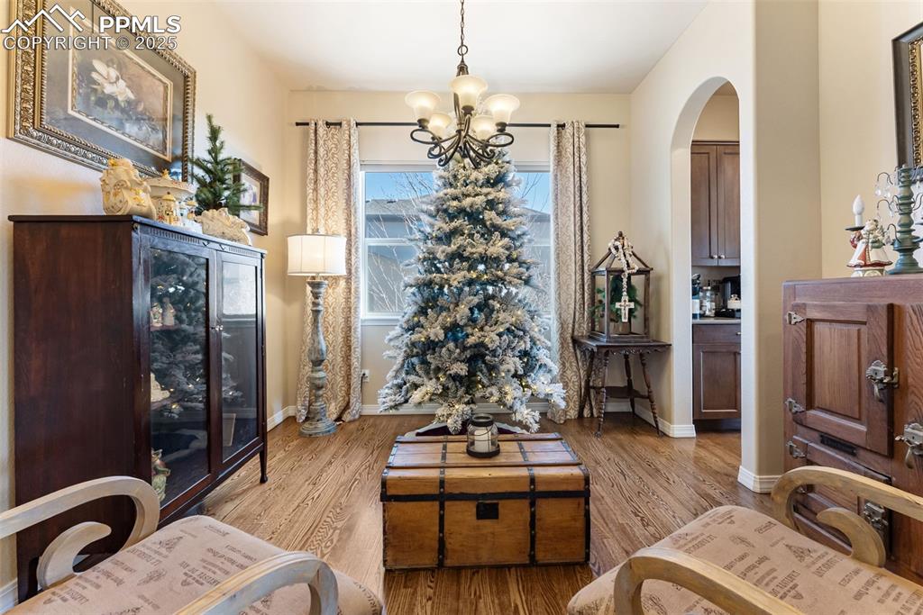 Image 11 of 50: Dining room with hardwood floors, a chandelier, and arched walkways. Curren
