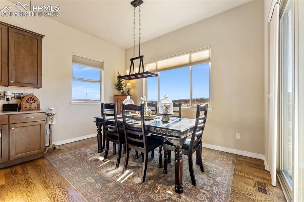 Image 13 of 50: Dining room attached to kitchen with hardwood floors, natural light, walk-o