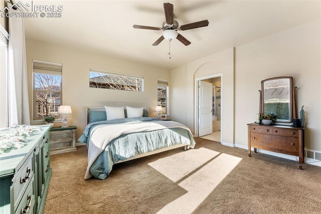 Image 20 of 50: Bedroom with light colored carpet and ceiling fan