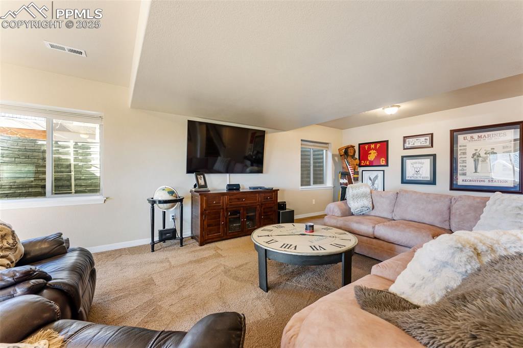 Image 28 of 50: Family room with walkout to covered patio with hot tub and gorgeous landsca