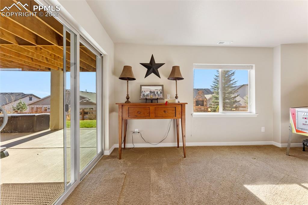 Image 31 of 50: Family room with walkout to covered patio with hot tub