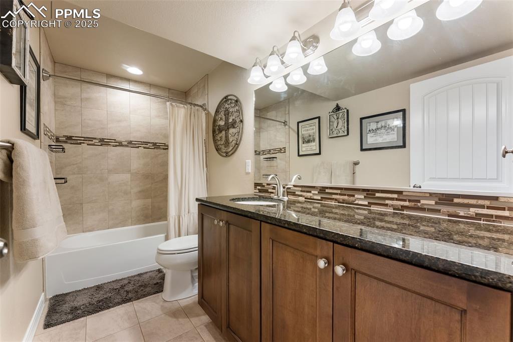 Image 32 of 50: Basement full Bathroom featuring vanity, shower / tub combo, light tile flo