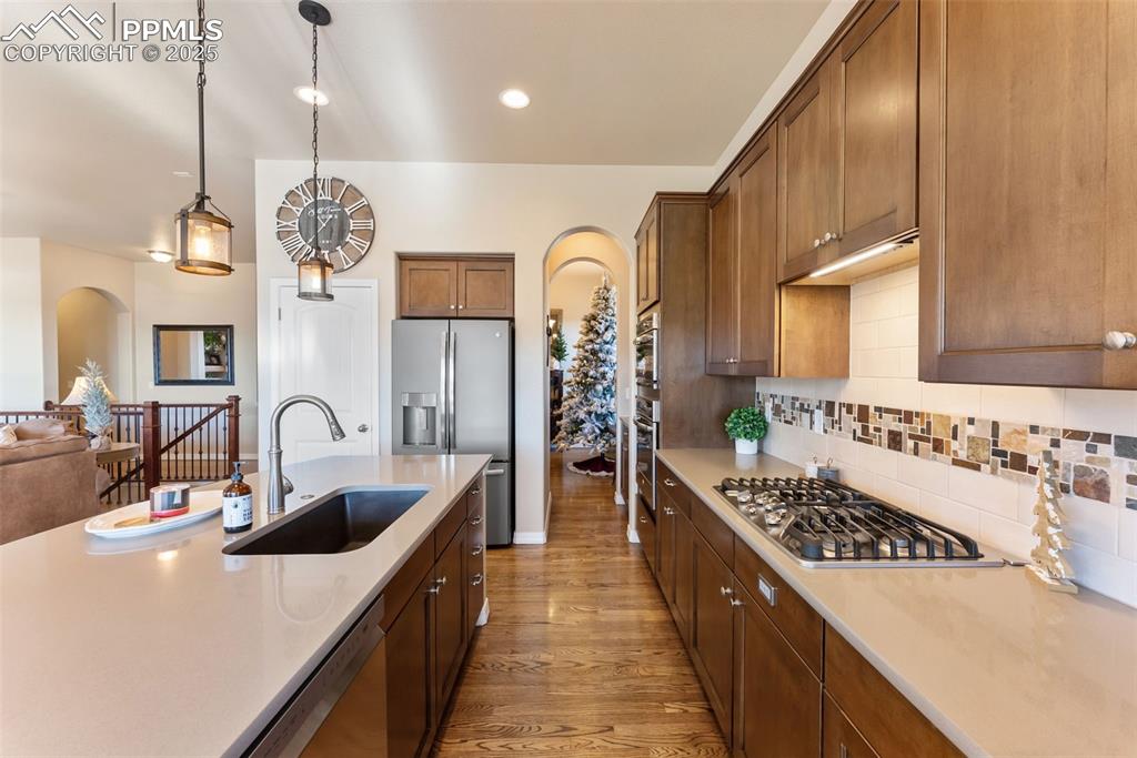 Image 7 of 50: Kitchen with pantry, hardwood floors, gas cooktop, stainless steel applianc