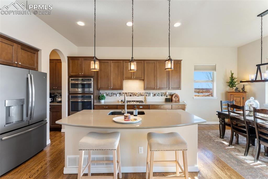 Image 8 of 50: Kitchen with stainless steel appliances, gas cooktop, large island, recesse
