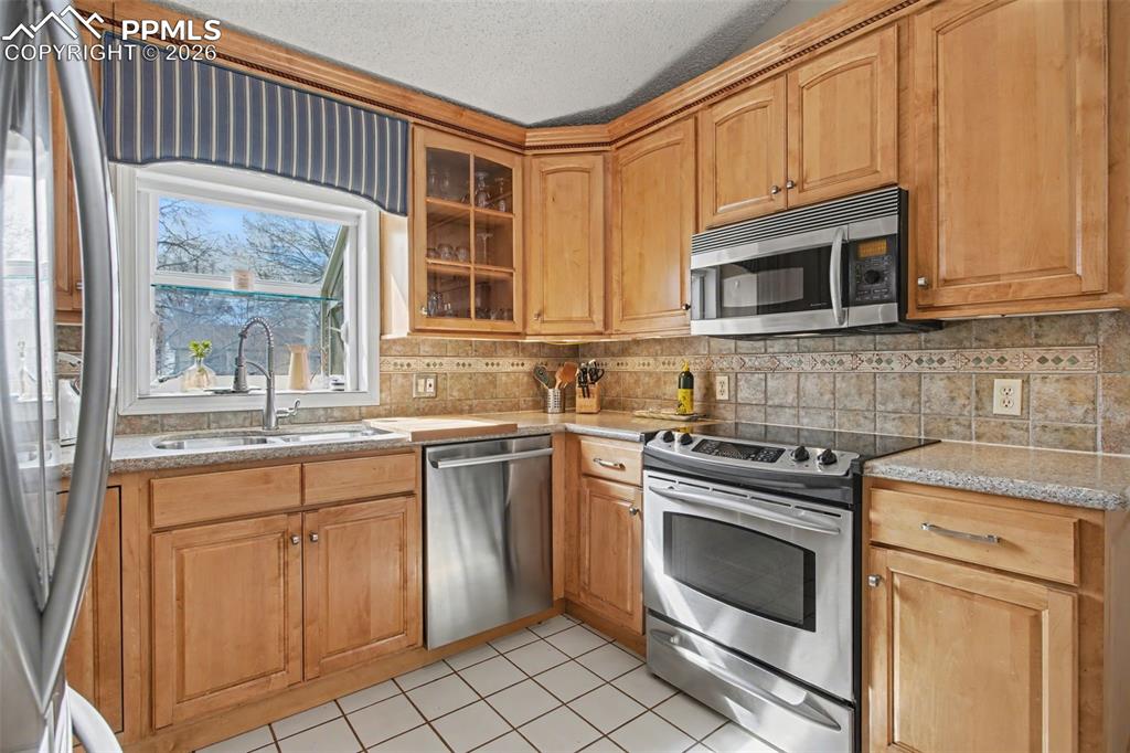 Image 12 of 42: Kitchen with tiled backsplash and garden window