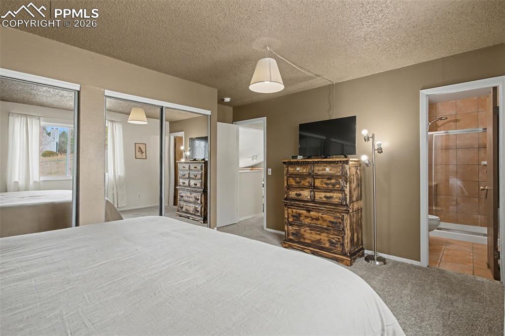 Image 21 of 42: Primary bedroom with view into adjoining bathroom