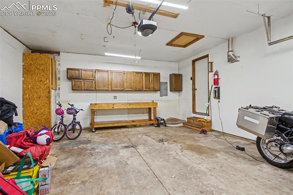 Image 30 of 42: Garage with work bench and cabinetry
