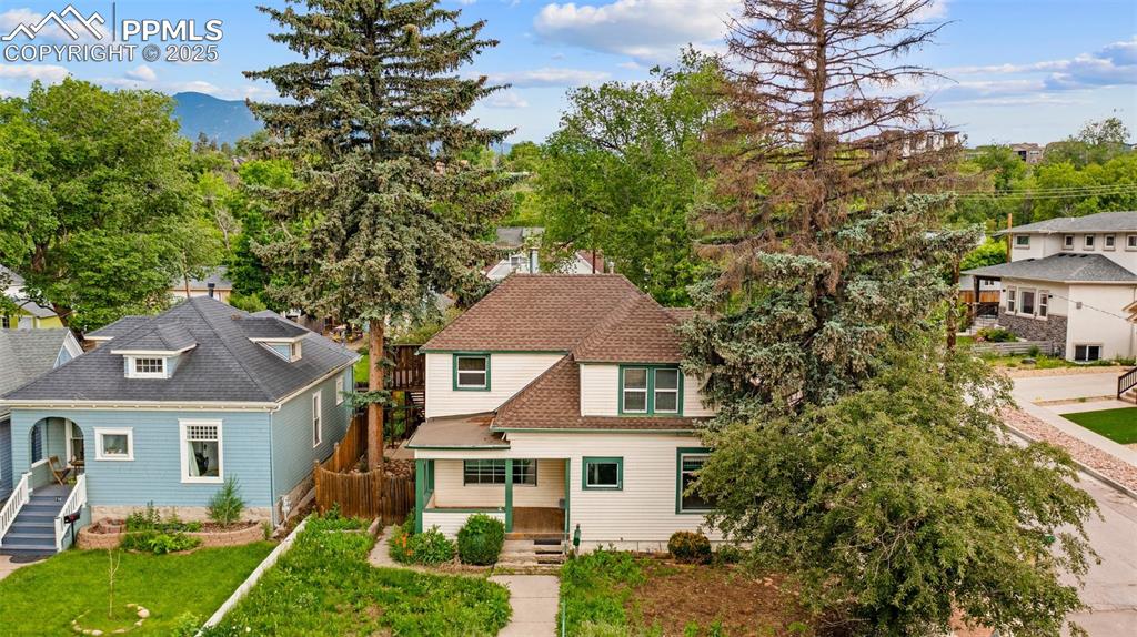 Caption: Charming front view of the home surrounded by mature trees.