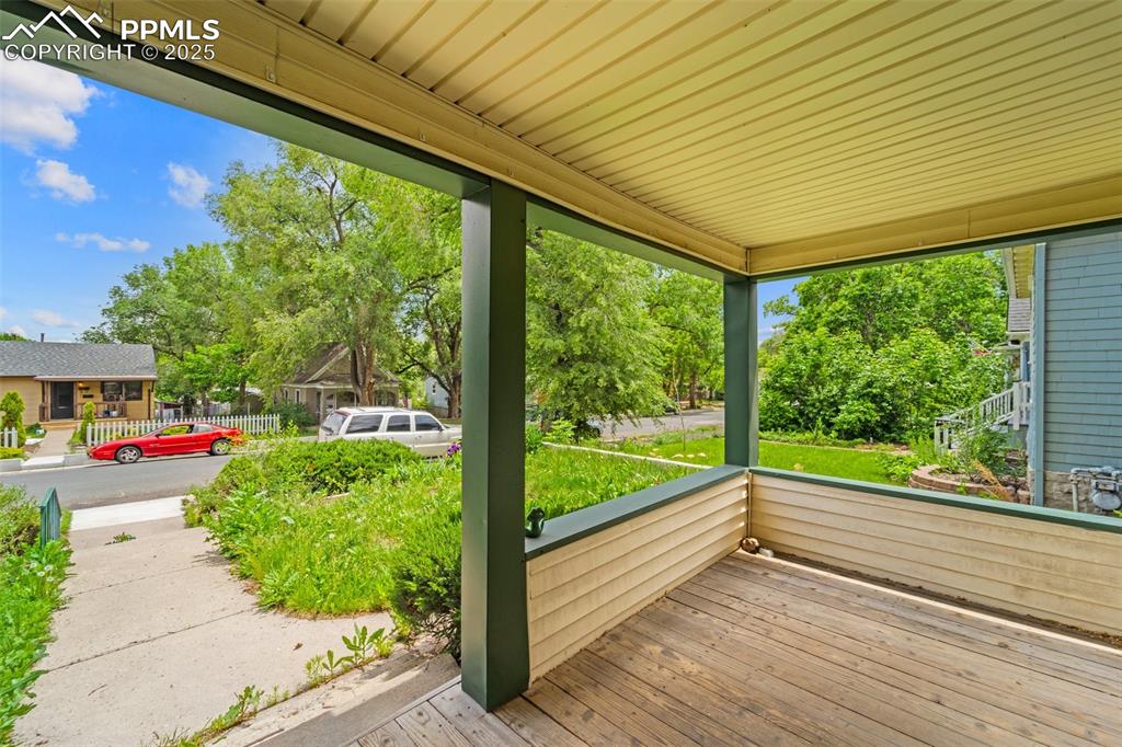 Image 17 of 48: Covered front porch perfect for outdoor dining.