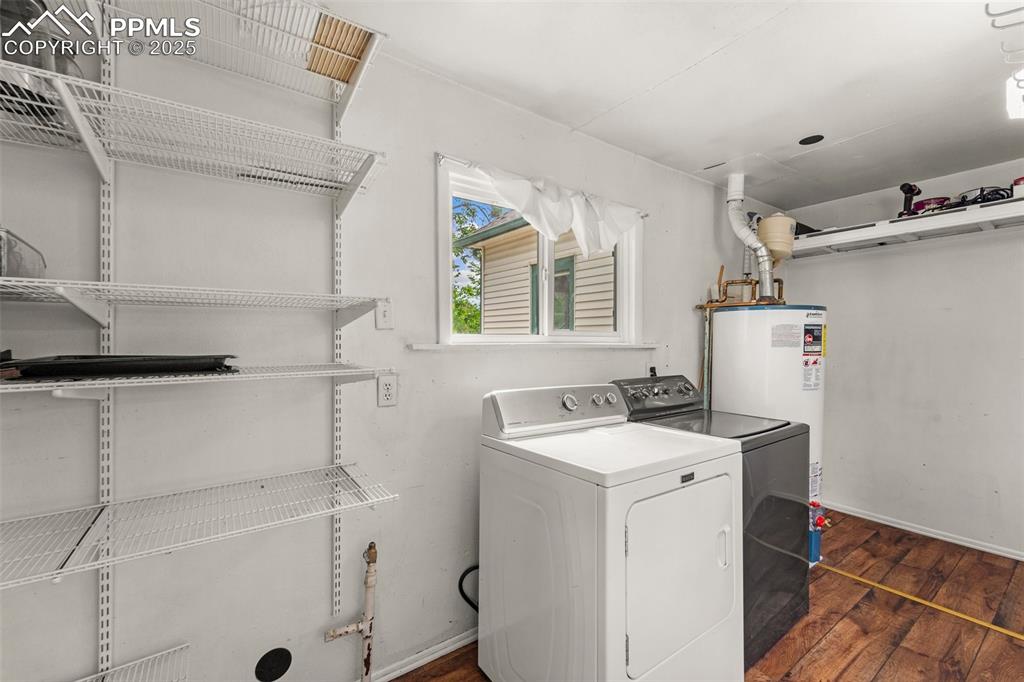 Image 31 of 48: Laundry area with washer/dryer and storage shelving.