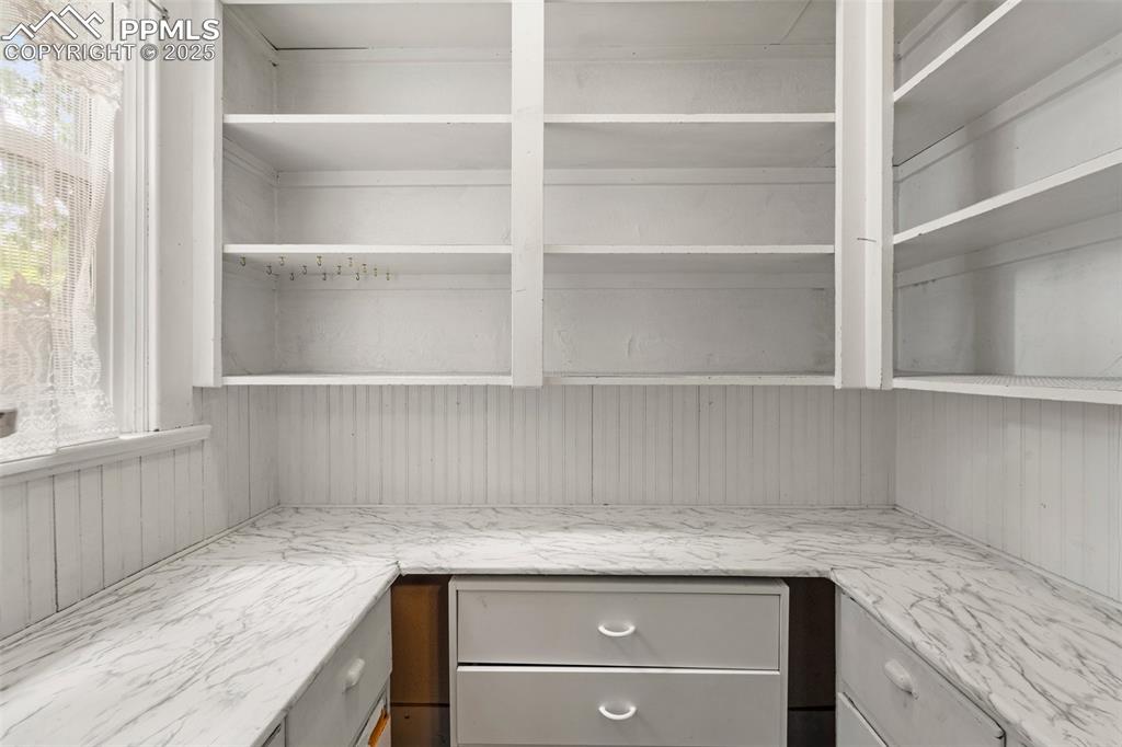 Image 32 of 48: Walk-in pantry with built-in shelving.