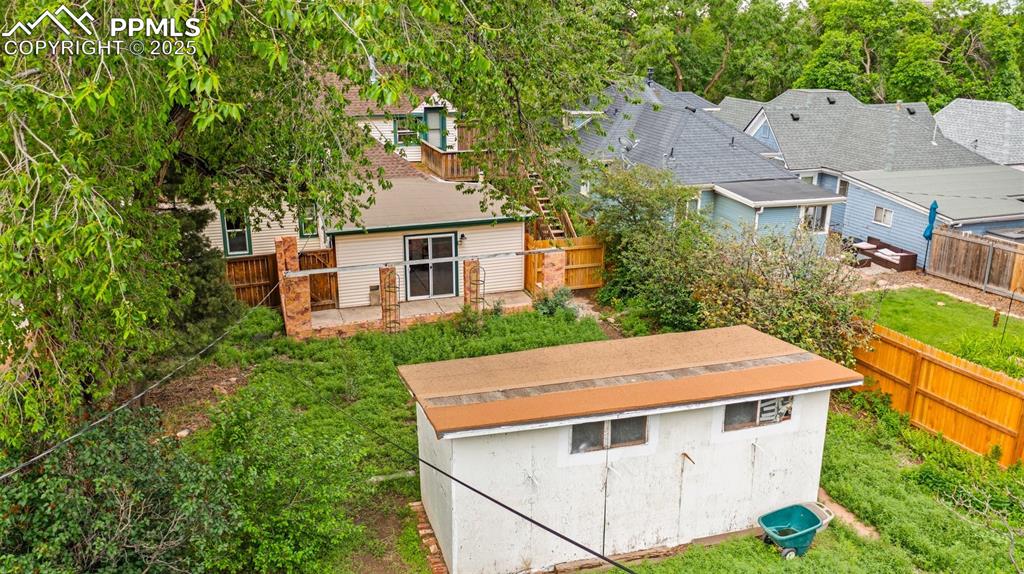 Image 6 of 48: Peaceful backyard with mature foliage and shed.