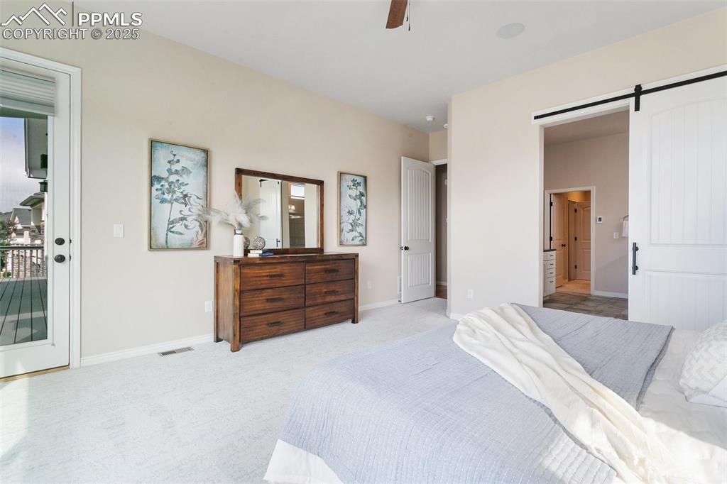 Image 17 of 41: Bedroom with access to exterior, carpet floors, a barn door, and a ceiling 