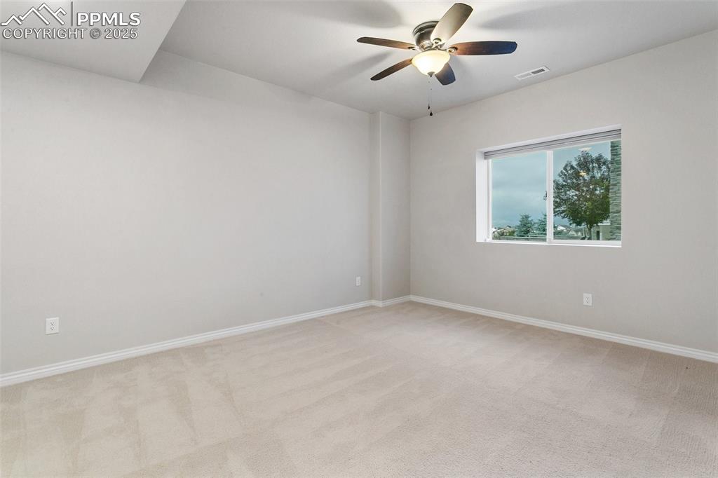 Image 27 of 41: Empty room featuring light carpet and ceiling fan