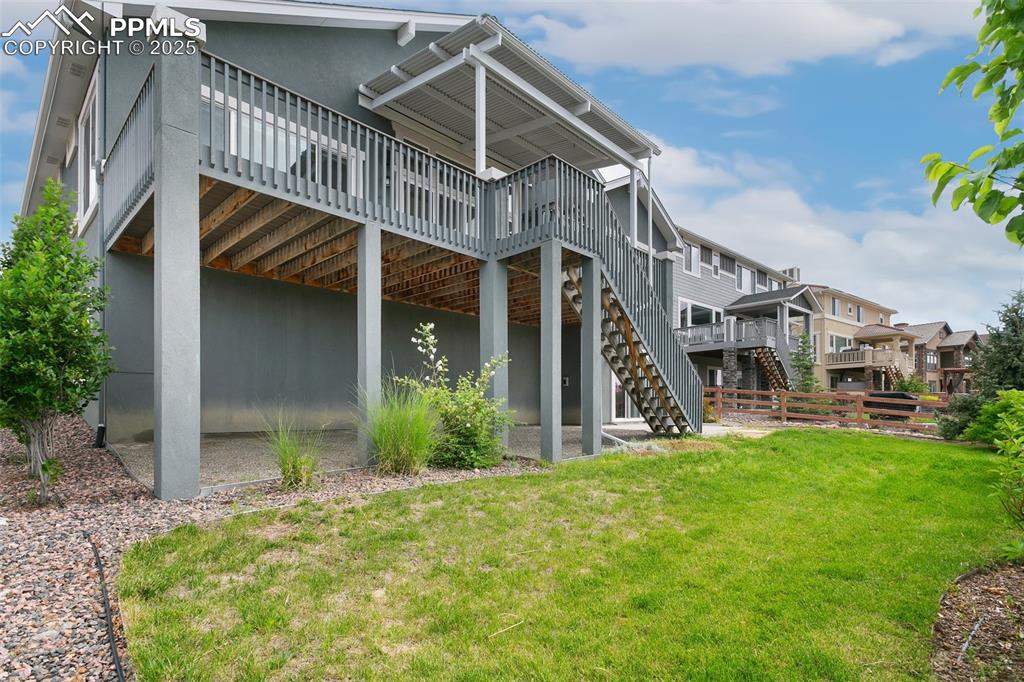 Image 37 of 41: Rear view of house with a deck, stairs, and stucco siding