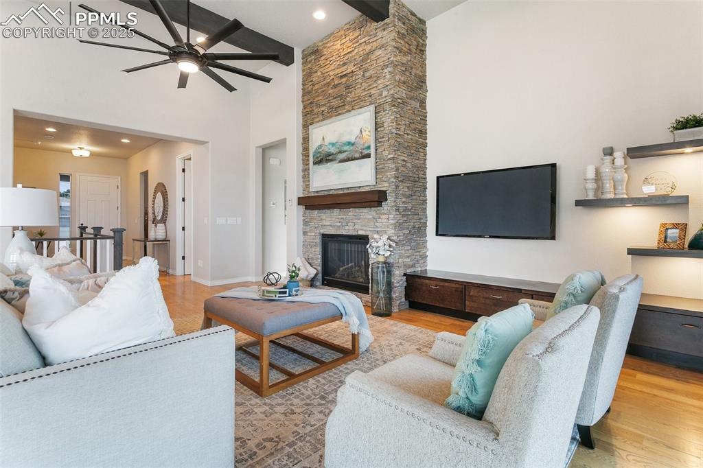 Image 7 of 41: Living area featuring ceiling fan, high vaulted ceiling, beam ceiling, wood