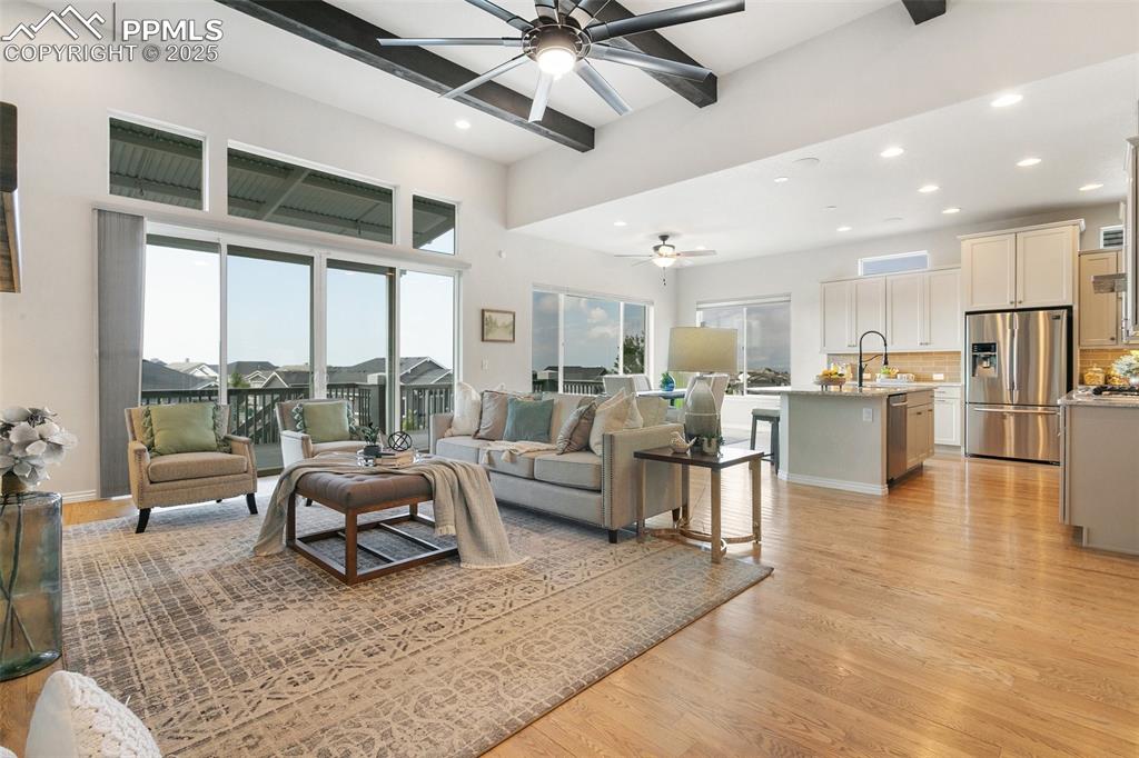 Image 9 of 41: Living room featuring ceiling fan, beam ceiling, light wood-type flooring, 