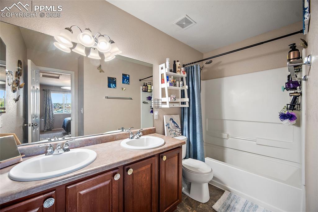 Image 20 of 47: Primary bathroom featuring double vanity and shower/ bath combo