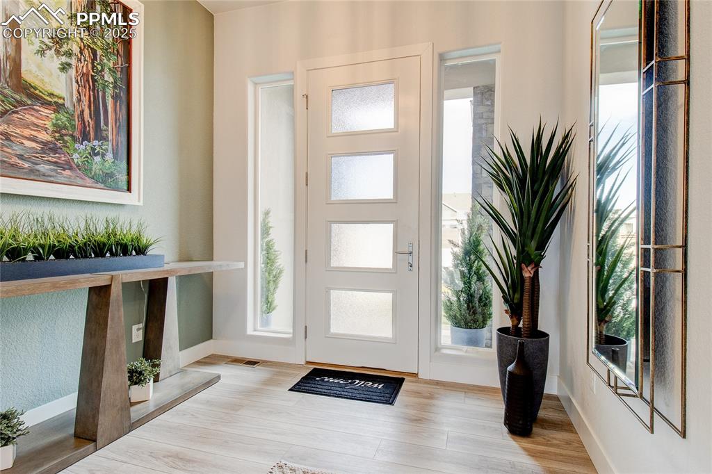 Image 2 of 30: Entrance foyer featuring wood finished floors and baseboards