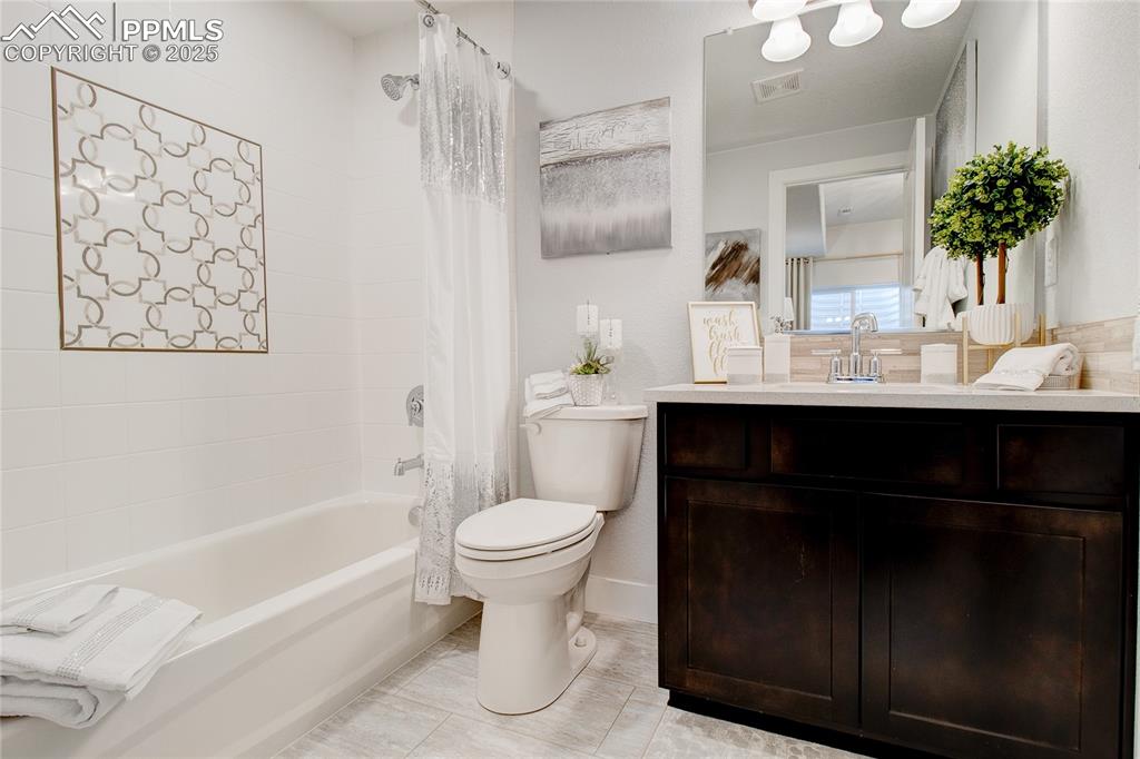 Image 22 of 30: Full bathroom with shower / tub combo with curtain, toilet, and vanity
