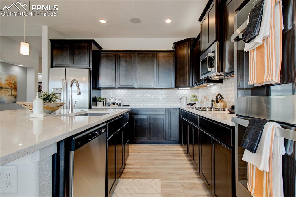 Image 8 of 30: Kitchen featuring appliances with stainless steel finishes, a sink, light w