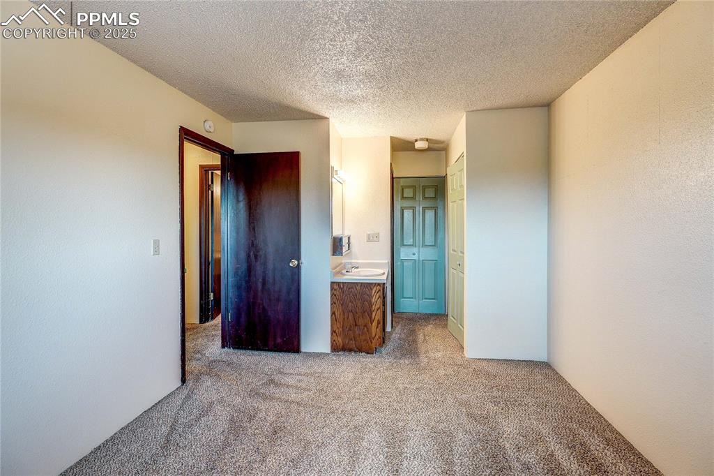 Image 17 of 20: Unfurnished bedroom featuring carpet flooring and a textured ceiling