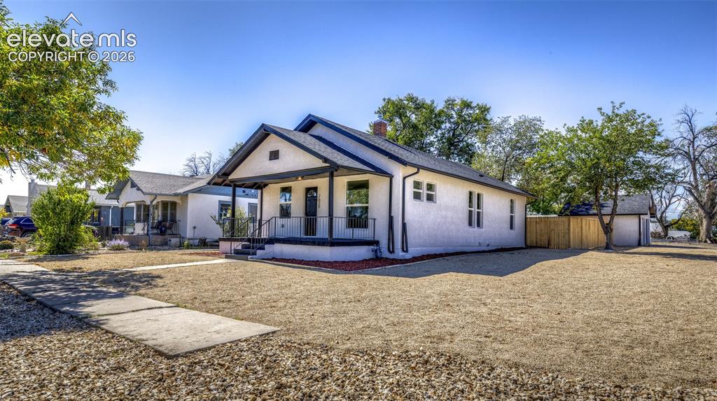 Image 2 of 33: Single-story residence featuring a light-toned textured exterior, metal-roo