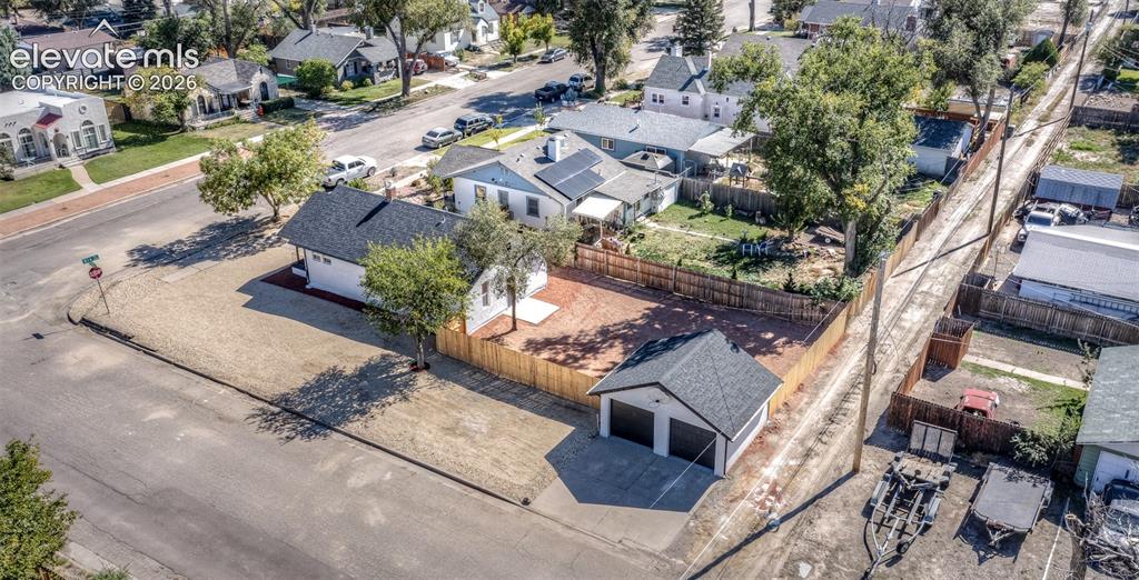 Image 33 of 33: Corner lot exterior featuring a detached two-car garage, fenced yard with s