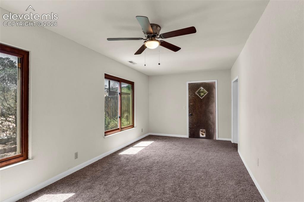 Image 12 of 29: Spacious room featuring neutral painted walls, brown carpeting, and a ceili