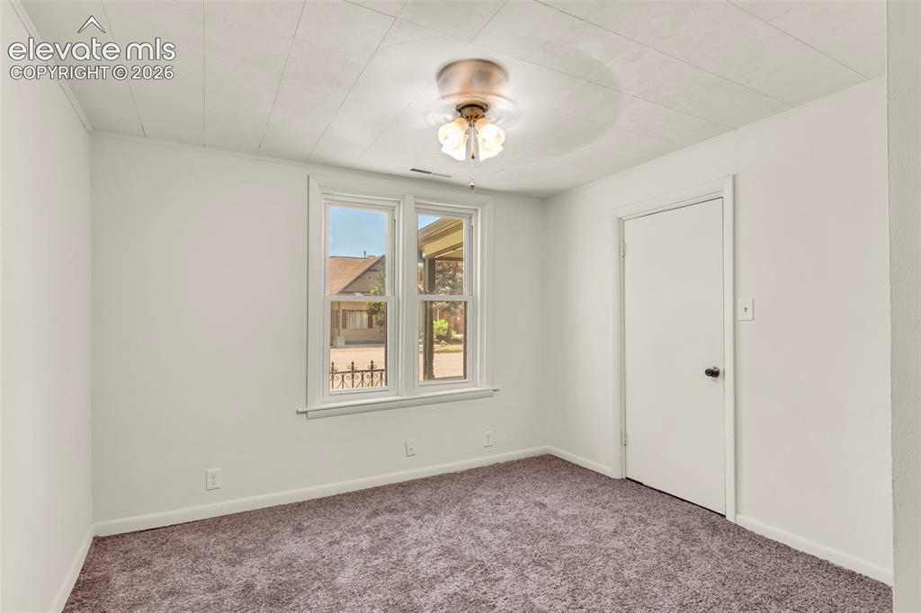 Image 16 of 29: Neutral-toned wall paint and grey carpet flooring