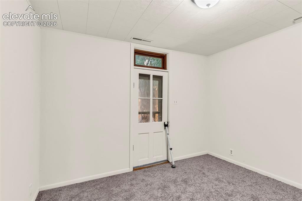 Image 19 of 29: Room featuring light gray carpeting, white painted walls, and a white panel