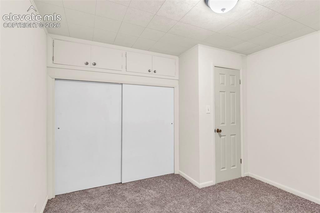Image 21 of 29: Neutral-toned carpeting extends throughout the room, complemented by white