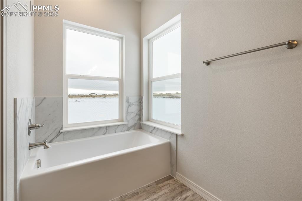 Image 16 of 36: Bathroom with wood-type flooring and a washtub