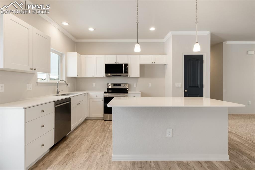 Image 34 of 36: Kitchen featuring sink, hanging light fixtures, stainless steel appliances,