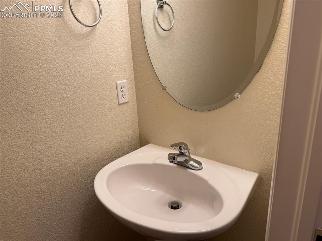 Image 10 of 32: Bathroom featuring a textured wall and a sink