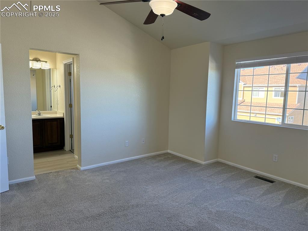 Image 11 of 32: Unfurnished bedroom featuring vaulted ceiling, light carpet, a ceiling fan,