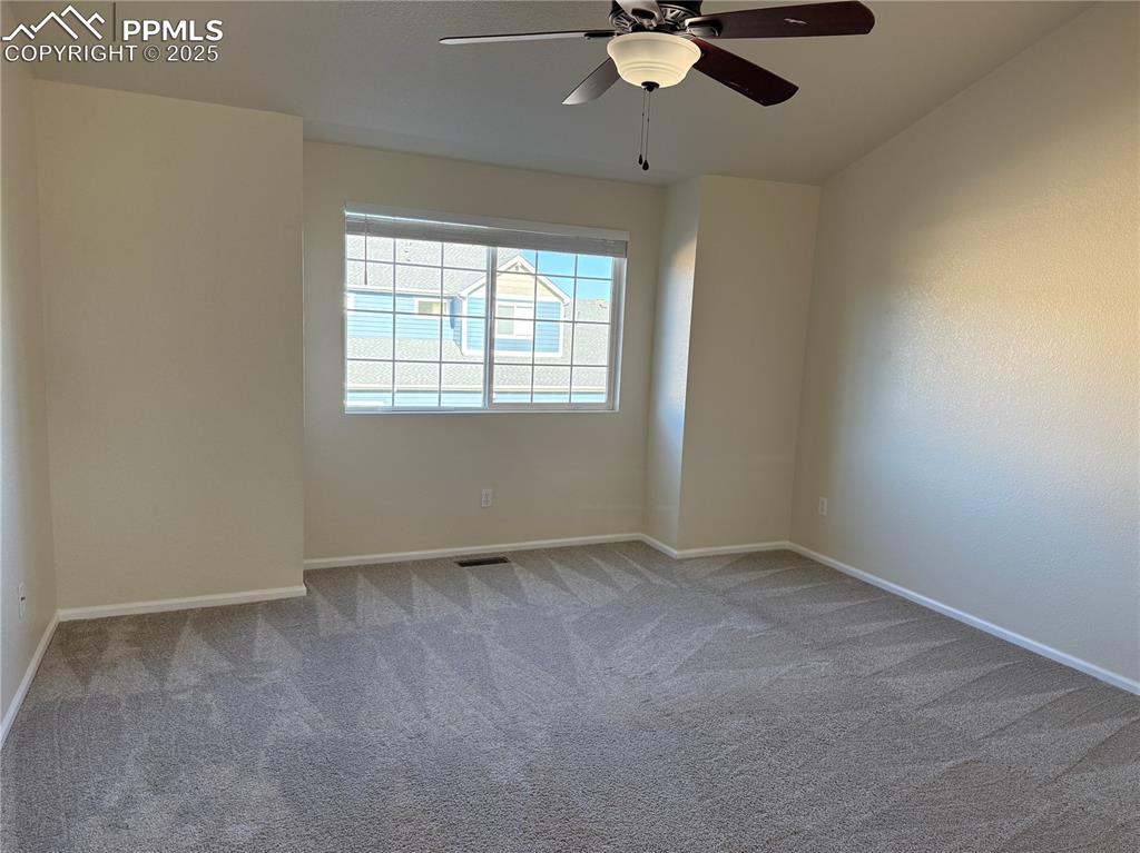 Image 12 of 32: Unfurnished room with carpet floors and ceiling fan