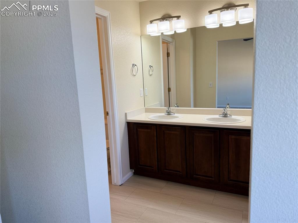 Image 13 of 32: Bathroom with double vanity and a textured wall