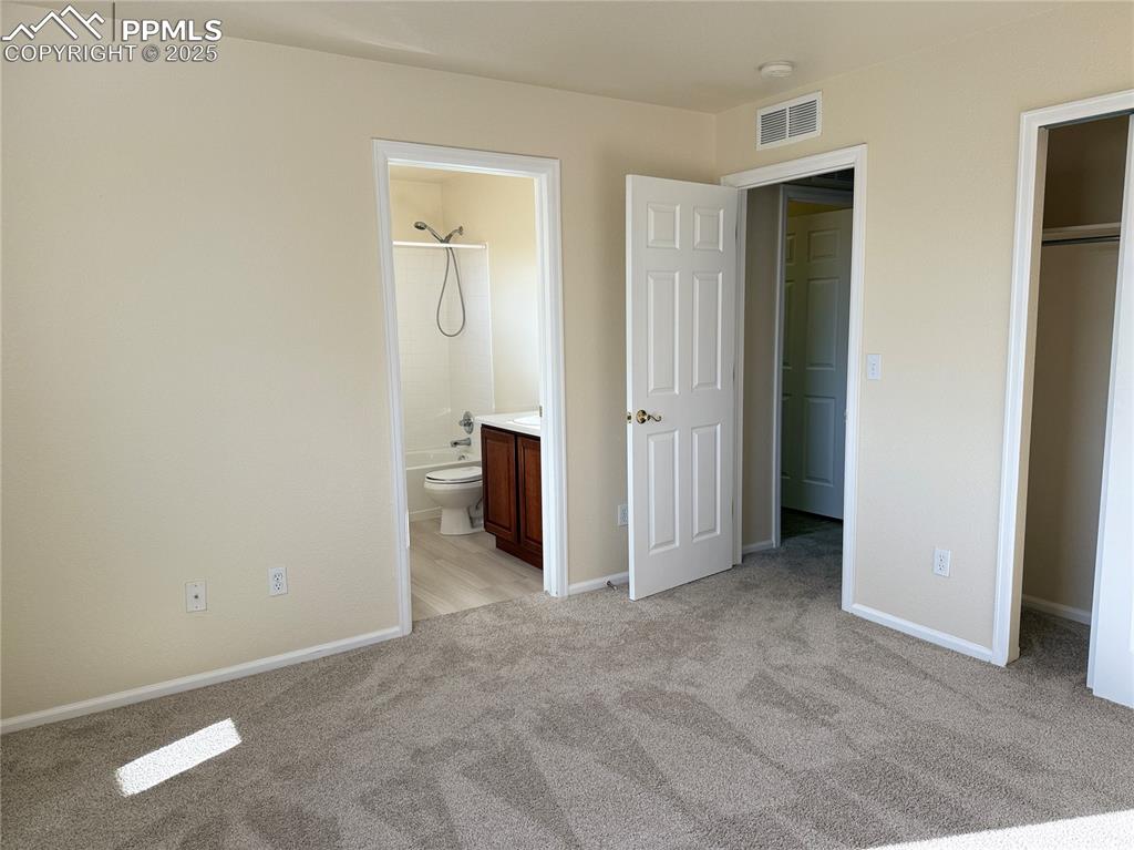 Image 19 of 32: Unfurnished bedroom featuring light carpet and ensuite bathroom