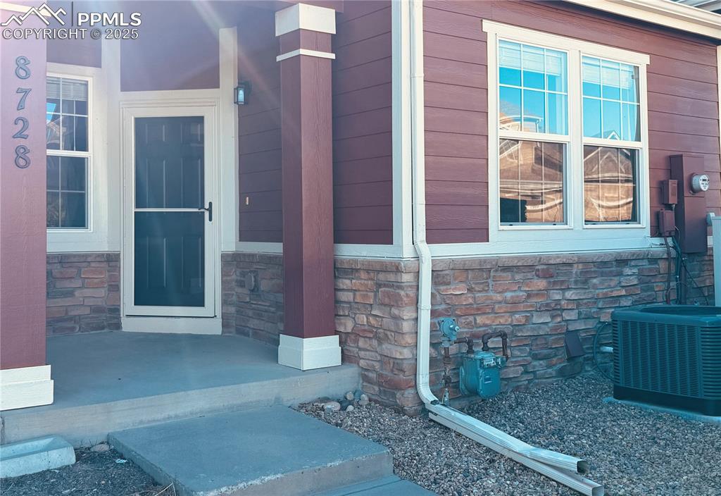Image 2 of 32: View of exterior entry featuring stone siding and a porch
