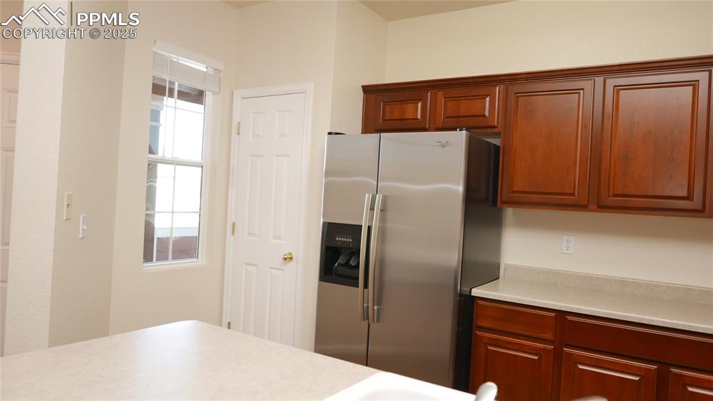Image 7 of 32: Kitchen with stainless steel fridge with ice dispenser, light countertops,