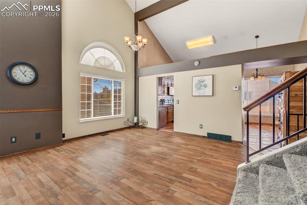 Image 2 of 35: Living room and dining room highlighted by vaulted ceilings. 