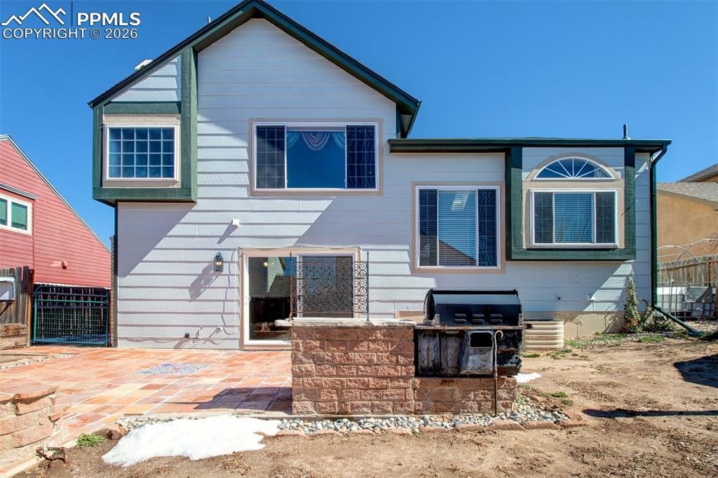 Image 32 of 35: Tile patio, gas firepit (capped off), built-in grill, dog run to the left a