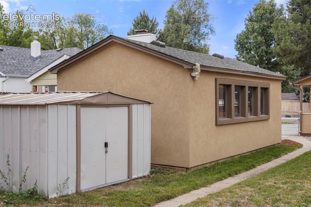 Image 15 of 23: Oversize garage with windows and storage shed