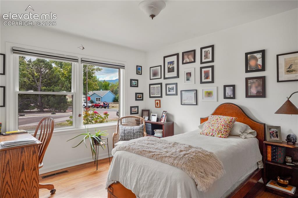 Image 6 of 23: Front Bedroom with big windows and hardwood floors